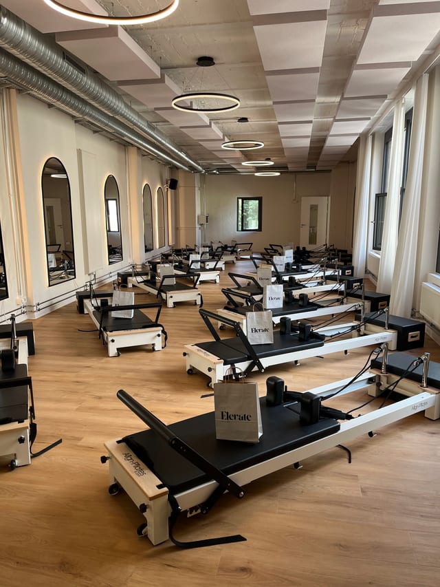 Elevate Pilates Reformer-Raum mit 15 Align-Reformern und großen Fenstern