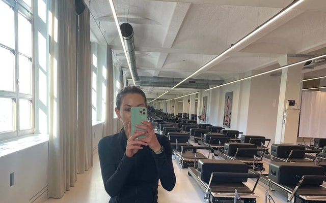 Simone auf dem Reformer bei YTTP Friedrichshain mit 40 Reformern im Hintergrund